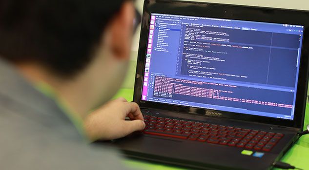 behind boy working on python code on laptop